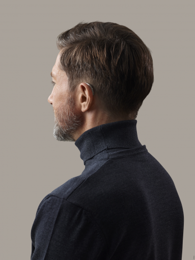 Mann trägt Oticon OPN S Hörgerät am linken Ohr Ansicht von hinten